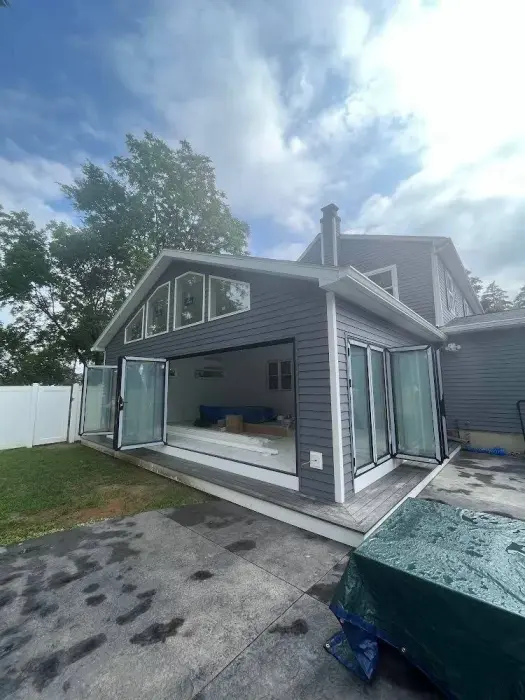 Modern grey house with large open bi-fold glass doors.