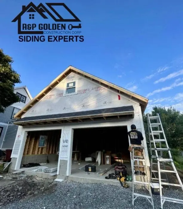 House under construction with open garage doors.