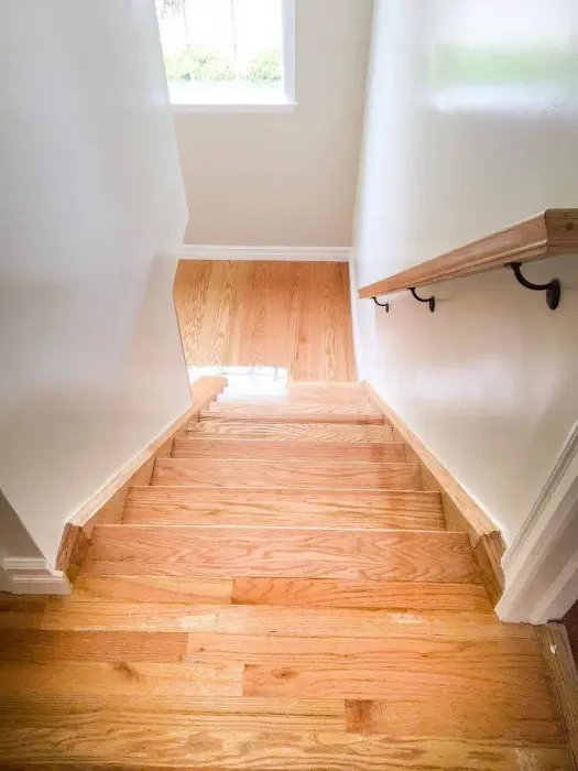 Interior view of wooden stairs and light hardwood flooring.
